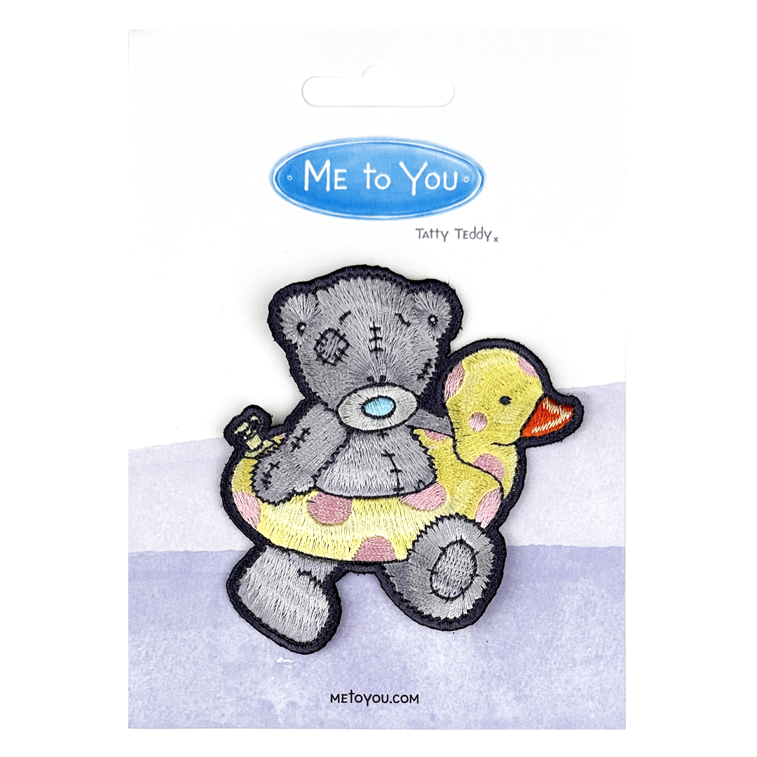 a picture of a teddy bear holding a rubber duck