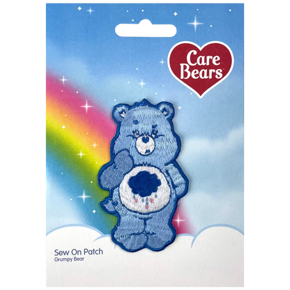 a blue teddy bear with a rainbow in the background