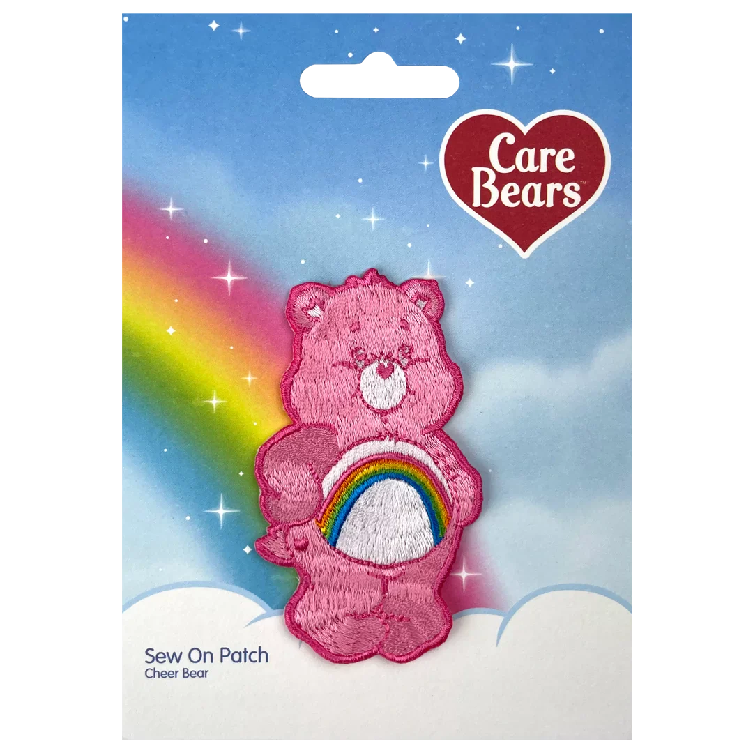 a pink teddy bear with a rainbow in the background