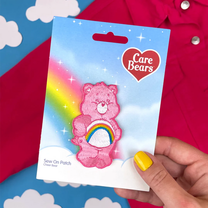 a hand holding a pink care bears sticker
