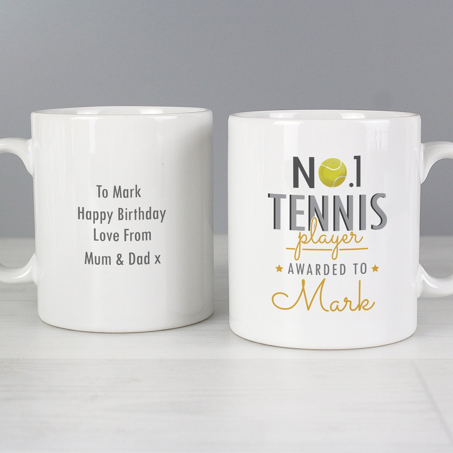 two white coffee mugs sitting on top of a table