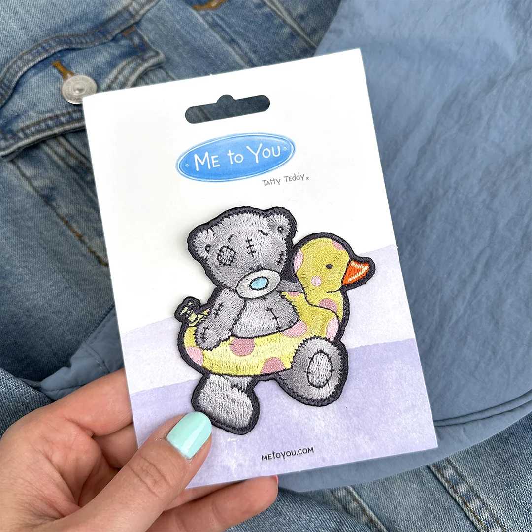 a person holding a sticker of a teddy bear with a rubber duck