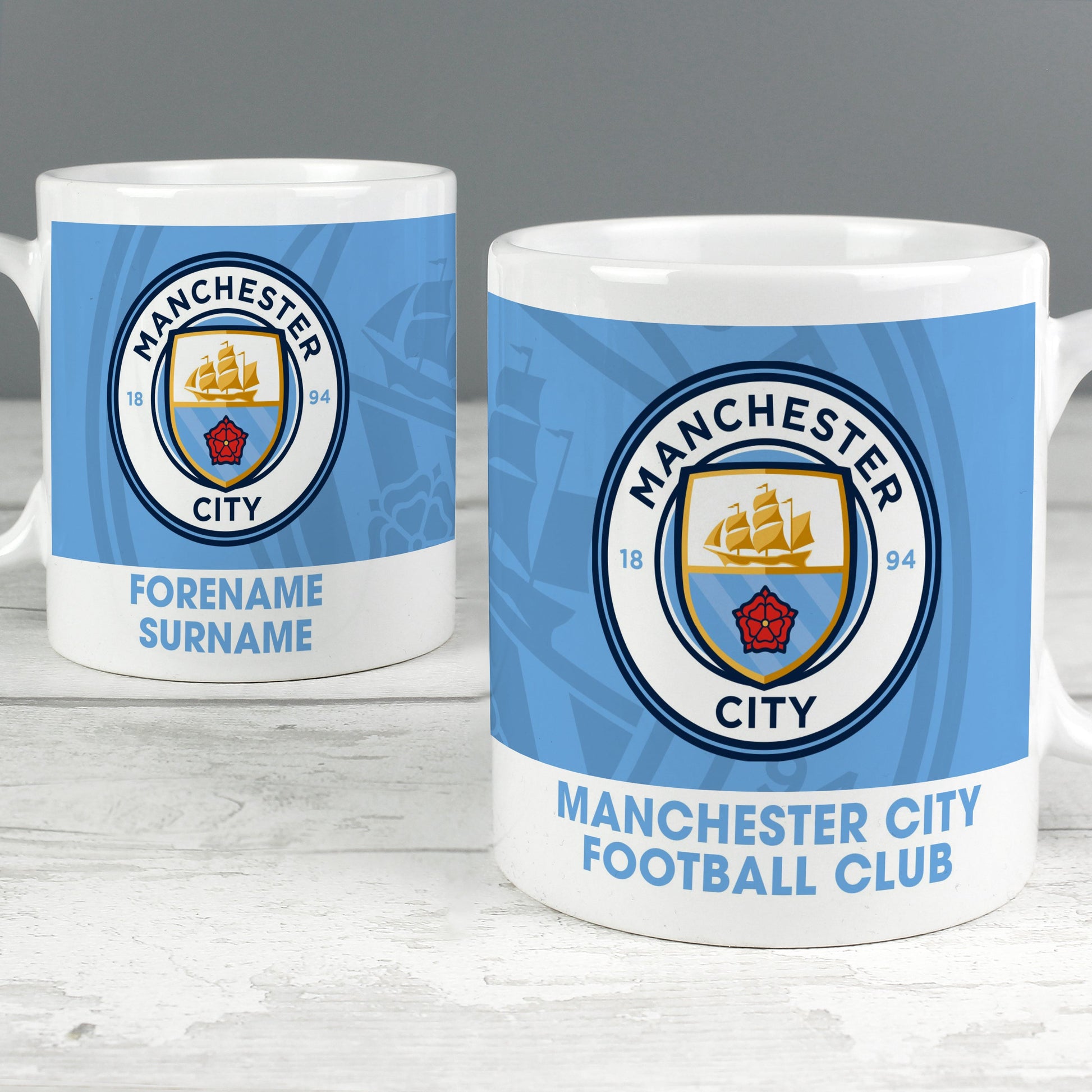 two mugs of manchester city football club on a table