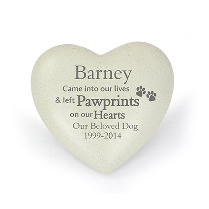 a white heart shaped memorial stone with a pawprints on it