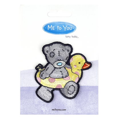 a picture of a teddy bear holding a rubber duck