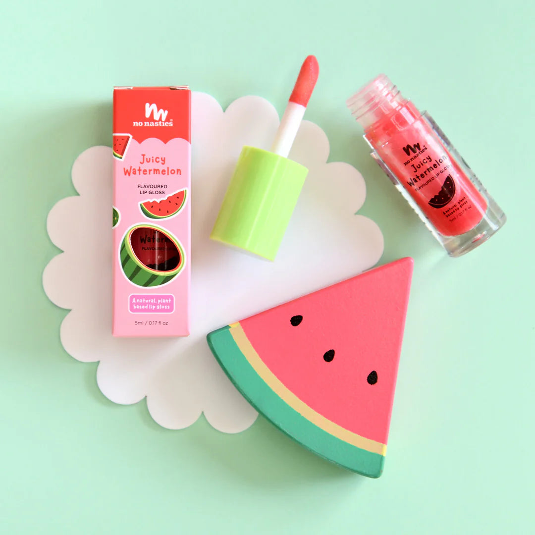 a watermelon lip balm next to a slice of watermelon