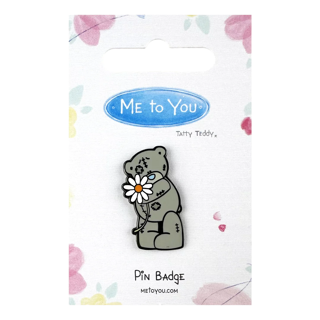 a pin badge with a bear holding a flower