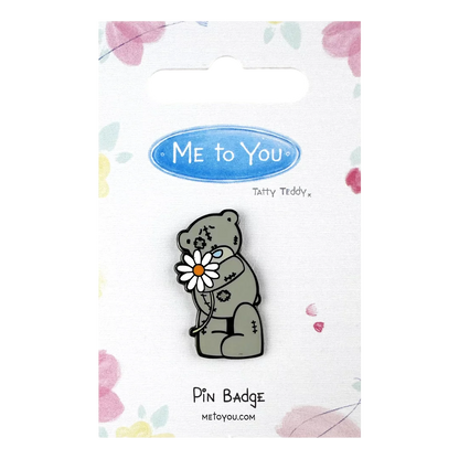 a pin badge with a bear holding a flower
