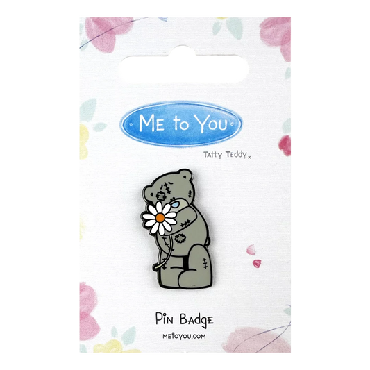 a pin badge with a bear holding a flower