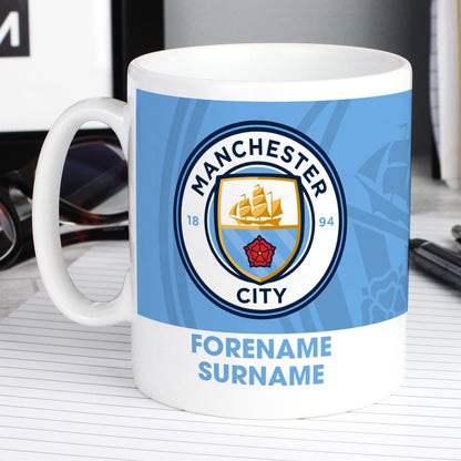 a white coffee mug with a manchester city logo on it