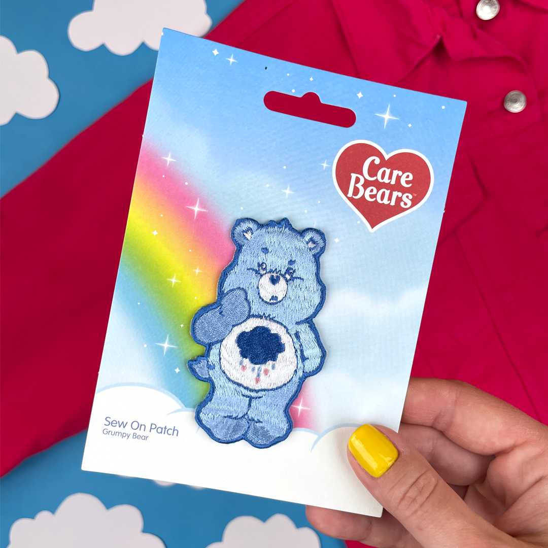 a person holding a care bears card with a bear on it