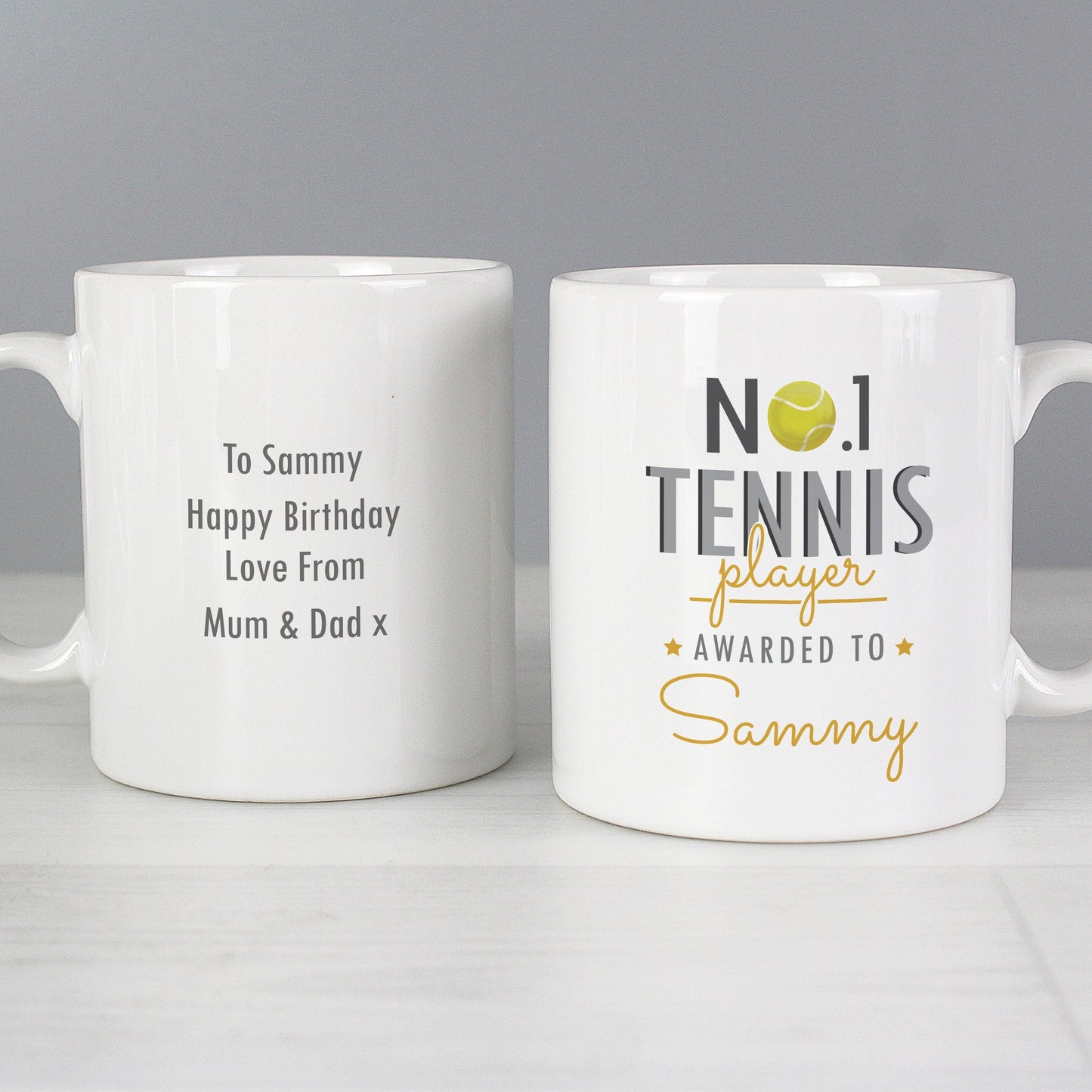 two white coffee mugs sitting on top of a table