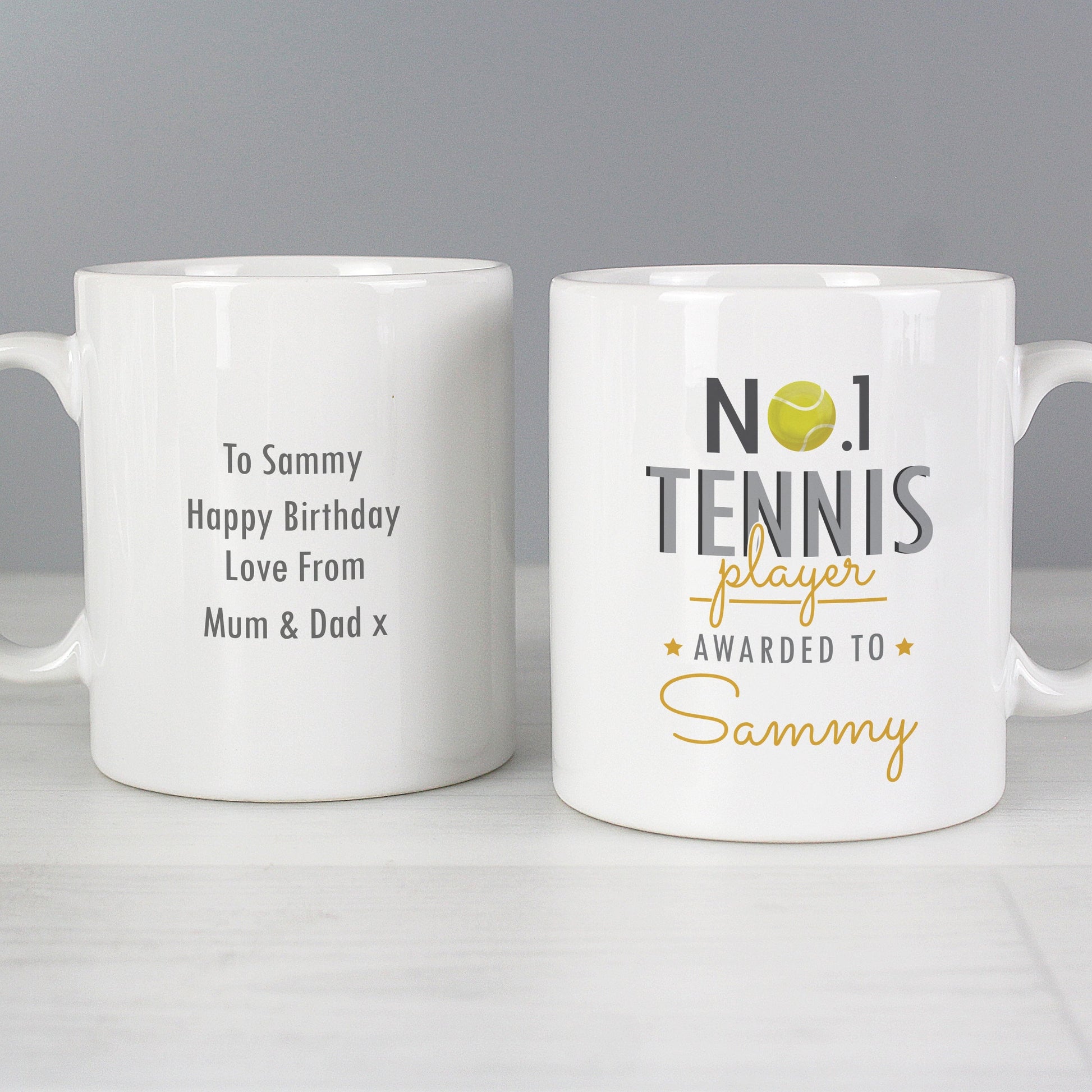 two white coffee mugs sitting on top of a table