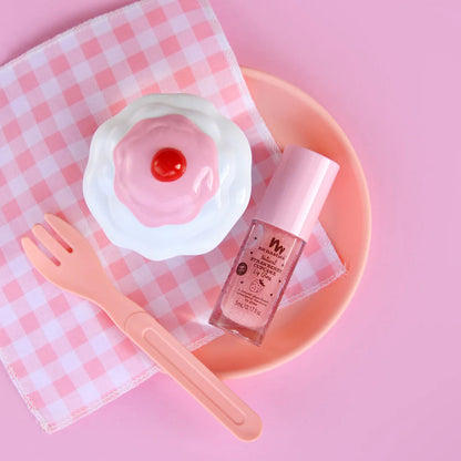 a pink plate topped with a pastry next to a fork