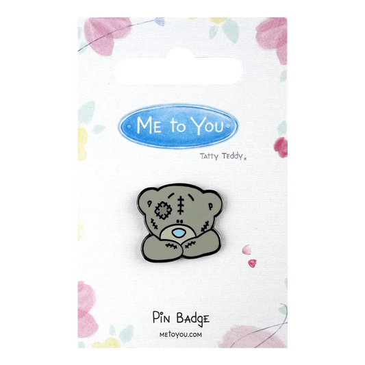 a pin badge with a teddy bear on it