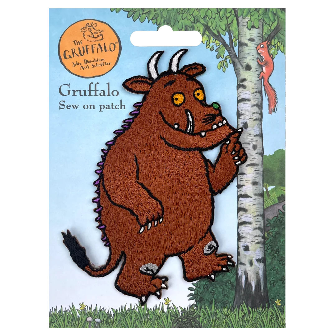 a felt picture of a brown troll standing next to a tree