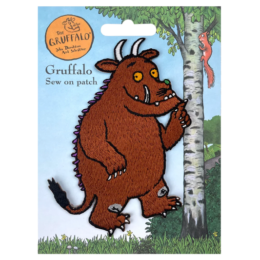 a felt picture of a brown troll standing next to a tree