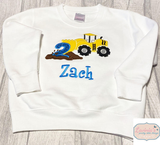 a white sweatshirt with a tractor and a name on it