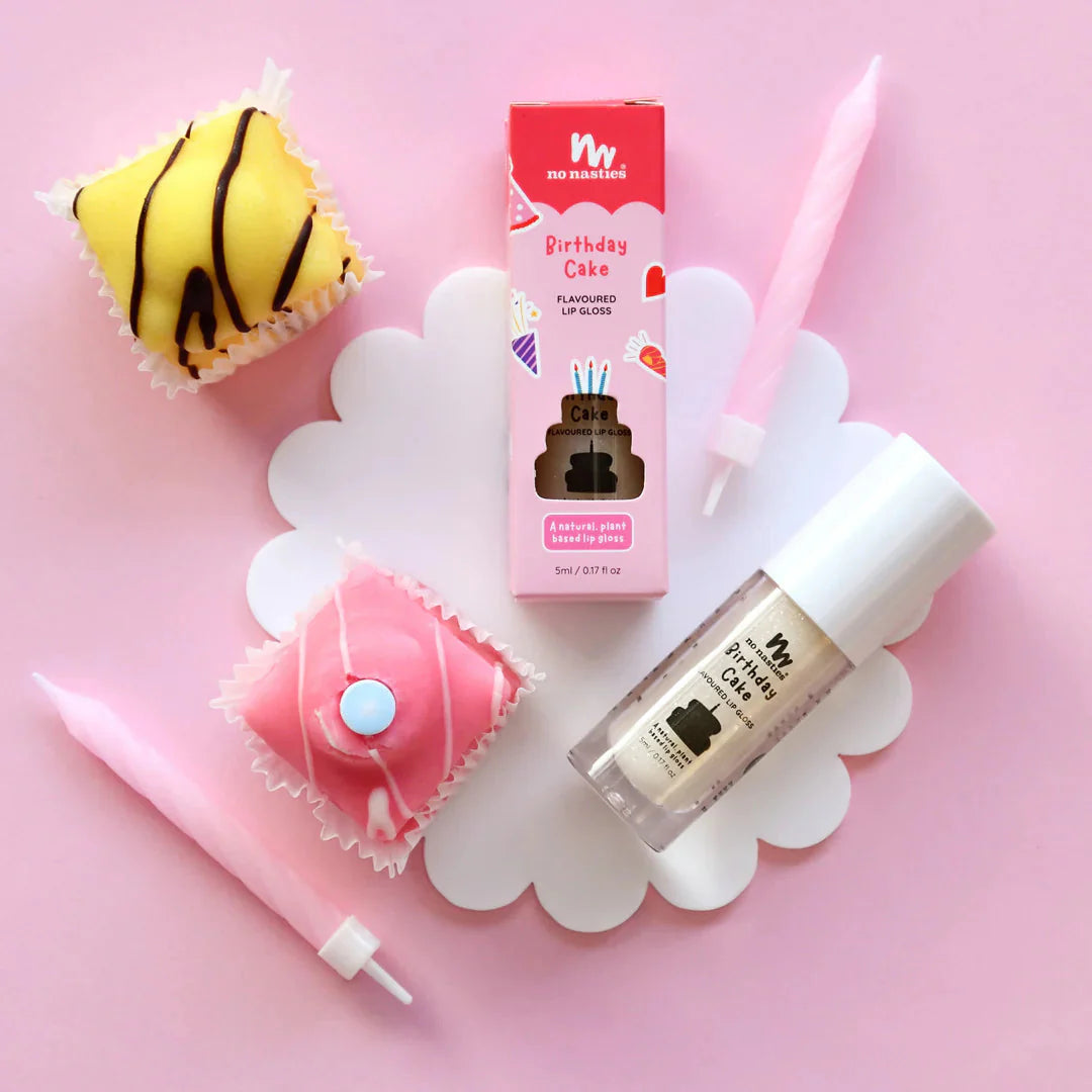 a cupcake, lip balm, and lipstick on a pink background