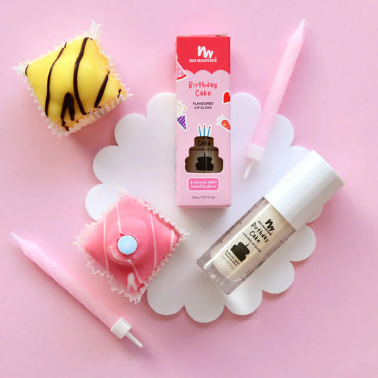 a cupcake, lip balm, and lipstick on a pink background