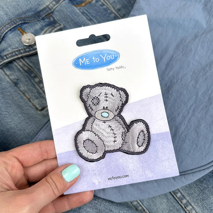 a person holding a sticker of a teddy bear