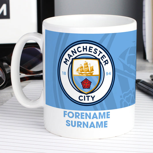 a white coffee mug with a manchester city logo on it