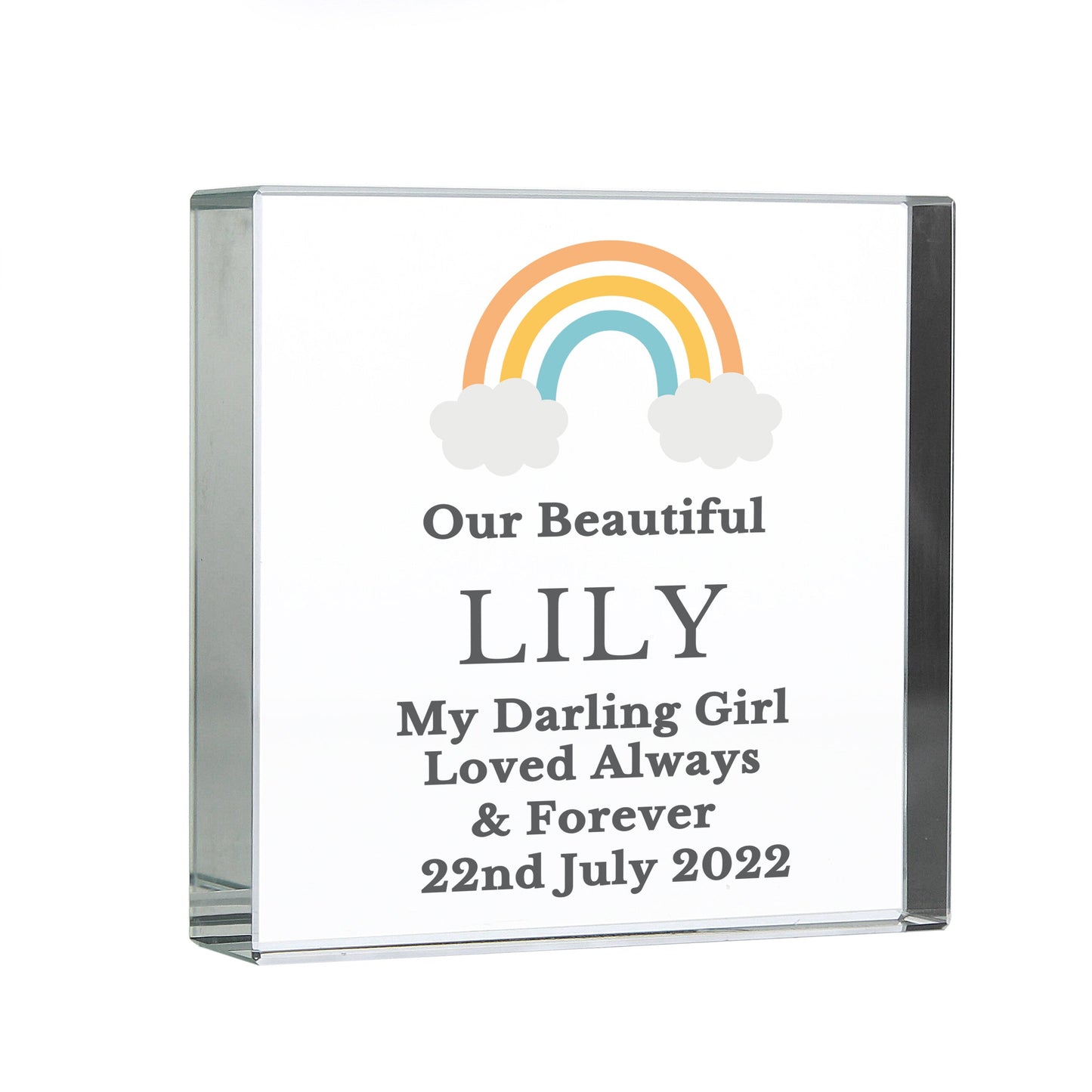 a glass plaque with a rainbow and clouds on it