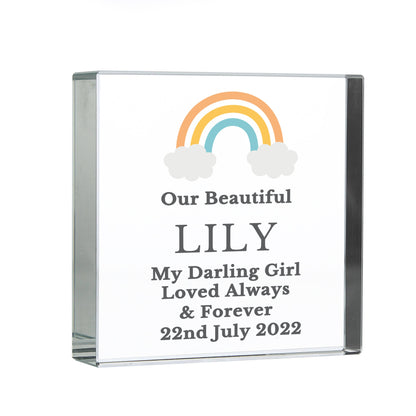 a glass plaque with a rainbow and clouds on it