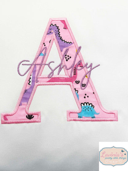 Embroidered pink dinosaur cushion