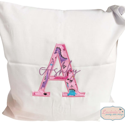 Embroidered pink dinosaur cushion